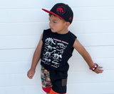 Child wearing a black sleeveless shirt with dinosaur graphics, colorful shorts, and a black and red Jurassic Snapback