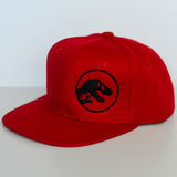 Red Jurassic Snapback with a black dinosaur logo on a light gray background