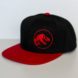 Black and red Jurassic Snapback with a dinosaur logo on a light gray background
