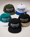 Five flat-brim baseball caps arranged on a light neutral background, each with the text 'DEGENERATE SOCIAL CLUB' embroidered on the front. The caps are shown in different colorways: olive green with white, white with blue, teal with white, black with white, and black with beige.
